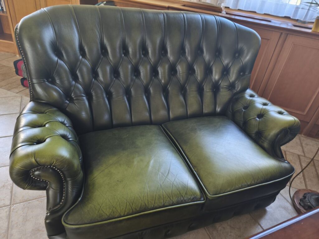 Kétszemélyes zöld Chesterfield kanapé felújítás előtt, gyűrött, elhasznált ülésekkel