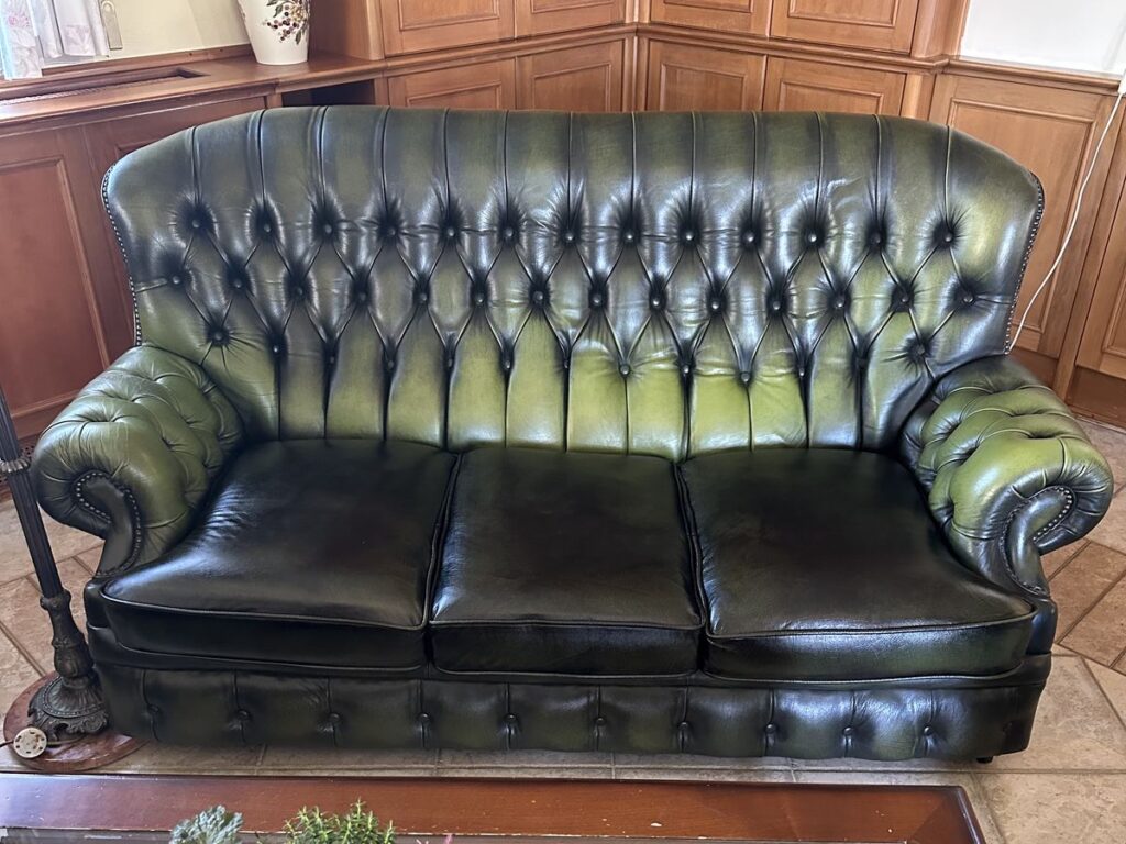 Ugyanaz a háromszemélyes Chesterfield kanapé az ülések újrakárpitozása után, Hand Antique Green bőrrel